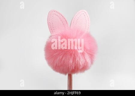 Pink Easter Bunny from fur silhouette, on a pink stick, isolated on a white background. Souvenir, decoration for Easter. Easter concept. copy space Stock Photo