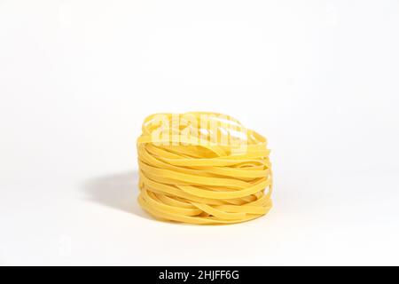 Italian pasta. Spaghetti Capellini isolated on white background with hard shadows. Pasta in the form of nests. Creative photo of pasta food. Stock Photo