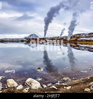 Power generation in the Bjarnarflag geothermal area of northern Iceland. Mirror reflection in the blue lake, with the Namfjoll mountain and steam plum Stock Photo