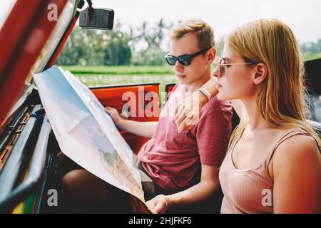 Trendy concentrated couple with map in car Stock Photo