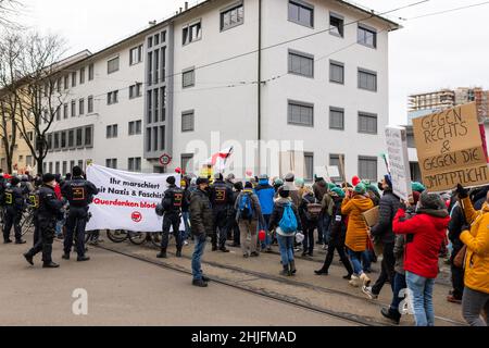 Freiburg Im Breisgau, Germany. 29th Jan, 2022. Participants of a demonstration against the Corona measures walk through Freiburg while counter-demonstrators with bicycles block the street holding a banner reading 'You march with Nazis & Fascists! Block lateral thinking!'. About 4500 people took to the streets to protest mandatory vaccination and pandemic containment measures, according to an initial police estimate. The organizer had expected about 7000 participants. Credit: Philipp von Ditfurth/dpa/Alamy Live News Stock Photo