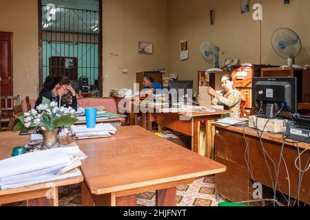 Interior of a Cuban office with people working. Lifestyle and economy in the island. Stock Photo