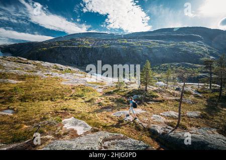 Kinsarvik, Hordaland, Norway. Young Woman Lady Tourist Traveler Backpacker Hiking In Hardangervidda Mountain Plateau. Famous Popular Destination Stock Photo