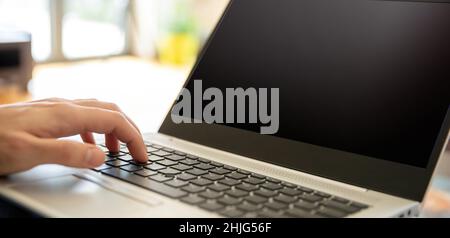 Man work at home office, open notebook, Male hand typing on laptop keyboard, close up view, selective focus. Stock Photo
