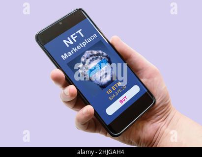 NFT art in phone, hand and smartphone with marketplace. NFT token is non-fungible cryptocurrency. Concept of blockchain, crypto tech, payment, digital Stock Photo
