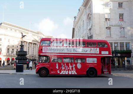 London, Greater London, England, January 5th 2022: Afternoon Tea red double decker bus driving through Piccadilly Circus.