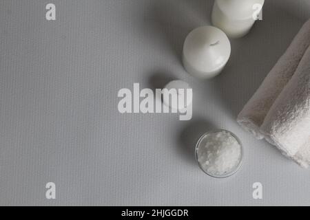 Spa treatments body care. Massage relax white candles towels and body scrub top view with space for text and with copyspace. Stock Photo