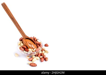 Peanuts with peanut paste in a wooden spoon. Isolated on a white background Stock Photo