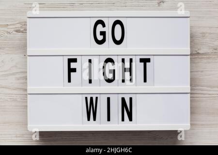 Lightbox with 'Go Fight Win' words on a white wooden background, top view. Overhead, from above. Flat lay. Stock Photo