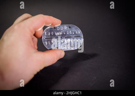 an old military dog tag of the army of the German Democratic Republic Stock Photo