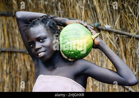 ETHIOPIA, Gambela, girl of Anuak tribe with pumpkin / AETHIOPIEN, Gambela, Dorf Tata der Ethnie ANUAK, Maedchen mit Kuerbis Stock Photo