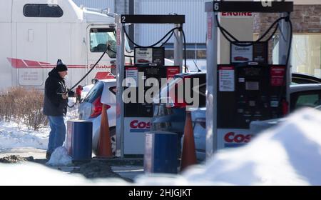 Toronto, Canada. 29th Jan, 2022. A man prepares to fuel a vehicle at a gas station in Toronto, Canada, on Jan. 29, 2022. The regular gas price in Toronto hit a record high to 1.529 Canadian dollars per liter on Saturday, according to local media. Credit: Zou Zheng/Xinhua/Alamy Live News Stock Photo