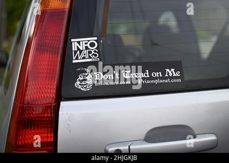 Two Info Wars stickers, with web addresses for infowars.com and prisonplanet.com, on the rear window of a silver vehicle Stock Photo