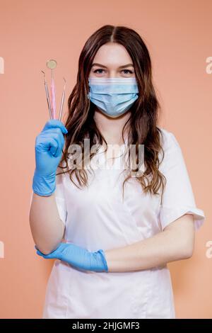 Handsome gloved dentist holding professional tools for dental treatment. Stock Photo