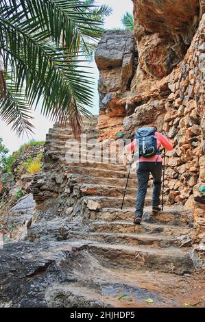 Senior woman climbing the stairs in traditional Oman village Stock Photo