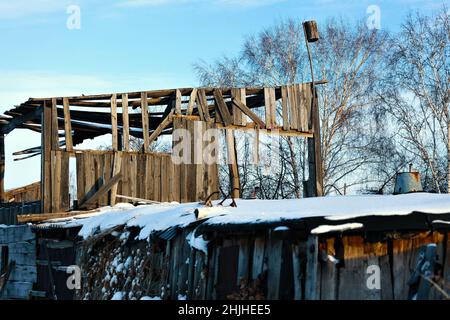 View of rustic wooden hayloft with birdhouse in winter. Abandoned village building. Rural view. Stock Photo