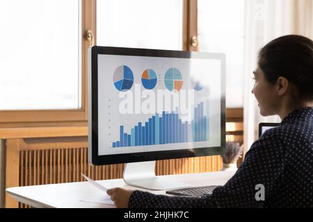 Focused young Indian businesswoman analyzing online sales. Stock Photo