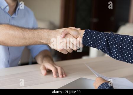 Close up Caucasian man shaking hands with Indian female partner. Stock Photo