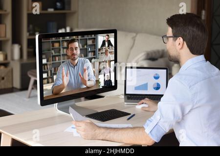 Smiling young employee working on different devices. Stock Photo