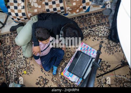father teaching their child to study with a laptop and come and operated a laptop . Stock Photo