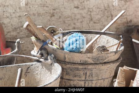 Plaster bucket full of very used construction tools. Selective focus Stock Photo