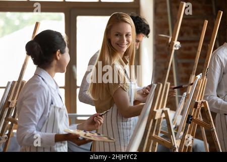 Happy hobby friends talking on art school class Stock Photo