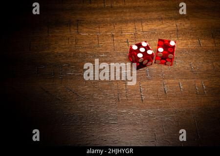 Professional casino-style dice on a wooden table with high-key lighting.