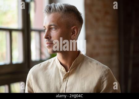 Serious thoughtful handsome millennial grey haired business man head shot Stock Photo