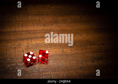 Professional casino-style dice on a wooden table under high-key lighting.