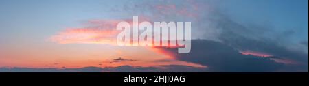 Dramatic gloomy panorama of bright saturated sunset with large dark clouds Stock Photo
