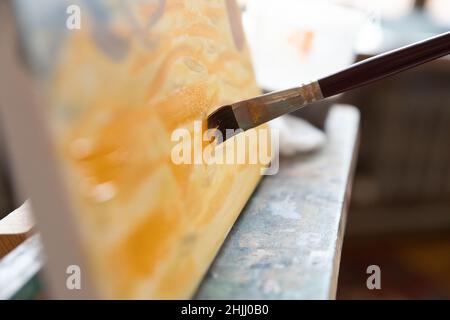 Close up of paintbrush bristle touching canvas Stock Photo