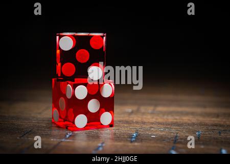 Professional casino-style dice on a wooden table under high-key lighting.