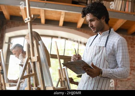 Focused inspired young student man engaged in creative class Stock Photo