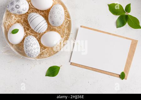 Easter composition with blank paper card and easter eggs Stock Photo