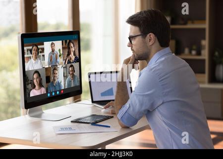 Concentrated millennial manager holding video call with colleagues. Stock Photo