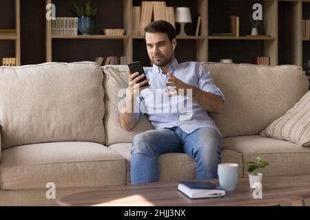 Happy relaxed young man holding video call. Stock Photo
