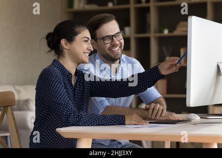 Happy young multiracial colleagues working on online project. Stock Photo