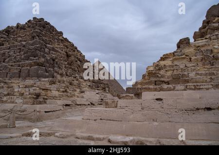 Ruins of the small pyramid of Queen Henutsen with Khafre Pyramids at background, Giza Plateau, Egypt. UNESCO World Heritage Stock Photo