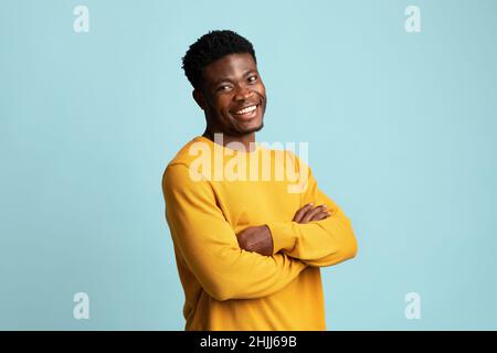 Positive young black man posing on blue Stock Photo