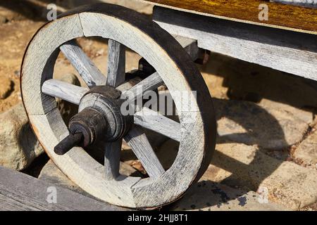 Close-up of an old wooden wheel on a rustic wooden wagon Stock Photo