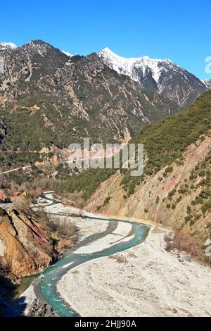 Beautiful winter landscape at the rural mountainous region of Agrafa, with Agrafiotis river and snowy peaks, in Evritania region, central Greece. Stock Photo