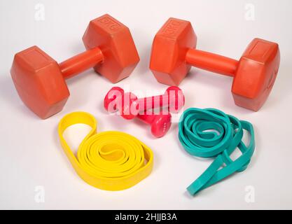 Dumbells and resistance bands used for home fitness workouts cut out isolated on white background