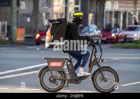 Bicycle courier of the fast delivery service Gorillas, delivers groceries, in currently over 20 German cities, within 10 minutes, orders via an app, B Stock Photo