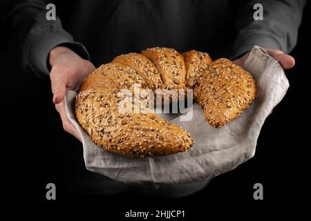 Holding freshly baked croissant in hands Stock Photo