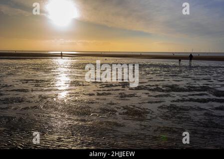 Crosby beach on the river Mersey at sunset ona winters afternoon with blown sand looking like a desert. Site of Another Place iron men statues, Stock Photo