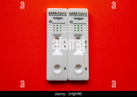 Zellik, Brussels, January 30, 2022. Two positive covid 19 self-tests on a red background. Biological examination that can be performed and interpreted Stock Photo