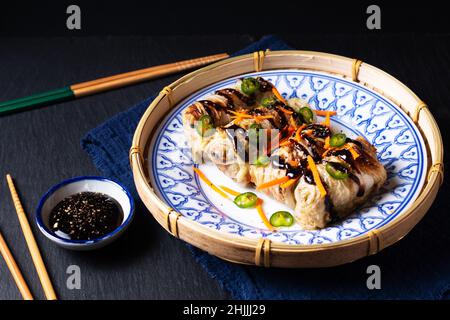 Food concept Homemade baked Chinese cabbage rolls in asian style ceramic plate with black slate stone background with copy space Stock Photo