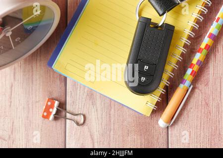 notepad, clock and car key on table  Stock Photo
