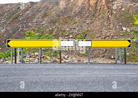 Blank road signs pointing at opposite directions at a crossroads in the countryside. Copy space. Stock Photo