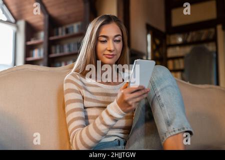 Portrait of smiling woman using smartphone at home Stock Photo